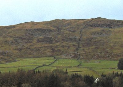 Castramon Hill viewed from the South East. One turbine (up to 250m) will be located towards the centre of the photograph, near the top of the hill on the North West facing slope. The elevation of the hill from the property shown is 150m. A 250m turbine would project around 200m from the top of the hill.